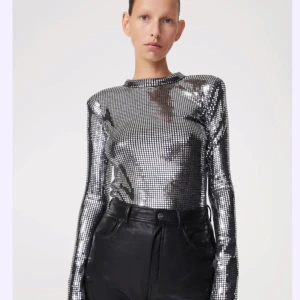 Glittrig paljettopp från Rodebjer - Snygg och glittrig paljettopp från Rodebjer i silver. Den har långa ärmar och axelvaddar för en cool look. Perfekt för festliga tillfällen när du vill sticka ut och glänsa som en discokula!