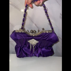 Lila kuvertväska med pärldetaljer - Dm för mer information 🌸