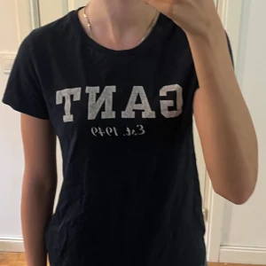 Marinblå t-shirt från GANT - Marinblå tshirt från GANT. 100 % bomull som glr den otroligt skön. En gant tshirt har nypris mellan 300-400 kr. Texten är i ”spräcklig” vet inte om det är designen eller om det är slitningar. Använd gärna köp nu💕