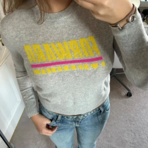 Grå kashmirtröja från From Future - Säljer en supermjuk och supersnygg grå kashmirtröja från From Future. Den har ett gult och rosa tryck med texten 'FORWARD' på framsidan. Tröjan är i mycket bra skick (använt få gånger för fyra år sen) och har inga skador, eller hål osv. Plus att tröjan inte är nopprig!!