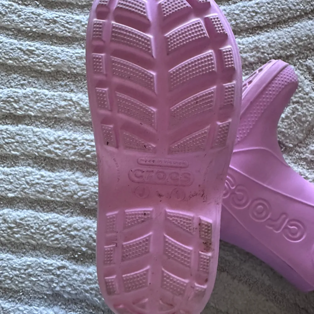 Säljer ett par supergulliga rosa Crocs-stövlar för barn 💕 Perfekta för regniga dagar med bra grepp på sulan. De har en praktisk design med handtag för enkel påtagning. Använda men i bra skick. Är osäker på storleken då det ändrat står J1 på sulan.. Skor.