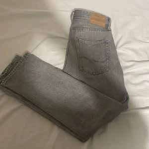 Grå jeansbyxor - Säljer ett par grå jeansbyxor i bra skick. De har en klassisk femficksdesign och är perfekta för både vardag och fest. Byxorna har en normal passform och är tillverkade i slitstarkt denim. Perfekta för höst och vår!