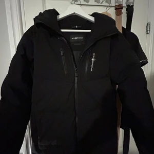 Svart dunjacka från Sail Racing - Säljer en svart dunjacka från Sail Racing i mycket bra skick (nästan som ny). Perfekt för kalla dagar med sin 500 fill power dunfyllning. Storleken är 170 barn men jag som är 178 passar den perfekt för. Nypris 3199. Mitt pris 1999. Hör av er vid minsta lilla fundering!