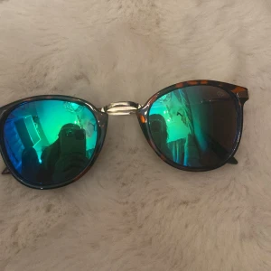Snygga solglasögon med spegelglas - Säljer ett par solglasögon med spegelglas. Bågarna har sköldpaddsmönstrad design och en silverfärgad brygga. Lite repor  