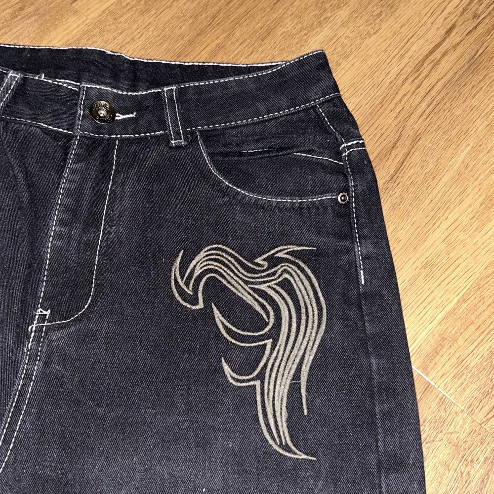 Svarta jeans med coola broderade vingdetaljer på baksidan och framsidan. Storlek xs men baggy så det passar s/m skulle jag säga🖤 innerbenslängden: Ca 70cm, men de ska hänga lite så det blir längre . Jeans & Byxor.