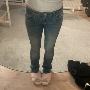 Blå jeans från LTB - Säljer mina absolut favorit jeans från LTB för jag har tröttnat. De är i bra skick och har en tight passform som sitter perfekt. Jeansen är lowwaist och har en klassisk femficksdesign med dragkedja och knapp framtill. Perfekta för både vardag och fest!