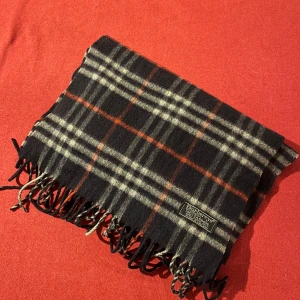 Halsduk från Burberry - En otroligt fin Burberry halsduk i marinblått, som knappt har använts och är i utmärkt skick. Den passar perfekt till många olika outfits och är tillverkad av 100% kashmir, vilket gör den både mjuk och varm. En perfekt accessoar för vintern! Jag skickar paketet antingen samma dag som köpet görs eller dagen efter. Kontakta mig gärna om du har några frågor! MVH Fideli❤️