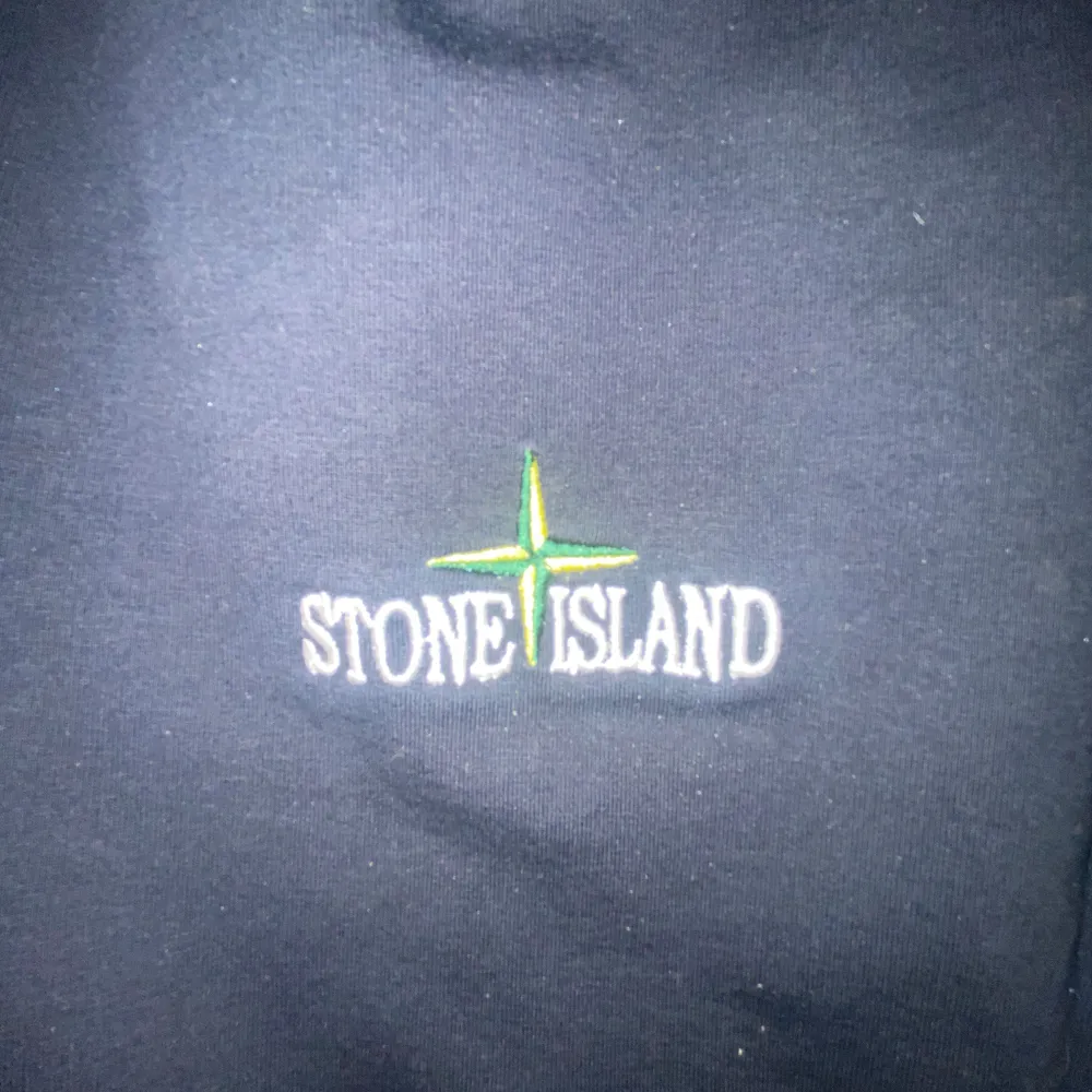 Säljer en snygg vit hoodie från Stone Island med dragkedja och huva. Den har en stilren design med broderad logga på bröstet. Perfekt för både vardag och chill. Passar bra till jeans eller mjukisbyxor. Hör av dig vid intresse!. Tröjor & Koftor.