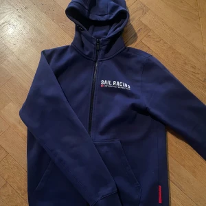 Mörkblå hoodie från Sail Racing - Säljer en snygg mörkblå hoodie från Sail Racing. Säljer för ej kommer till användning 