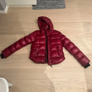 Röd pufferjacka från superdry - Säljer en snygg röd pufferjacka från superdry! Perfekt nu till vintern❤️ Jättebra skick, enda defekten som finns är att haken man hänger upp jackan på har gått sönder. Hör av dig vid frågor☺️ Färgen är mer rättvis på första bilden