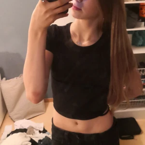 Svart croppad topp med öppen rygg  - Säljer en svart croppad topp från Sister i storlek XXS. Toppen har korta ärmar och en snygg snörning i ryggen som ger en unik look. Perfekt för en utekväll eller fest! 🖤 Pris kan diskuteras 