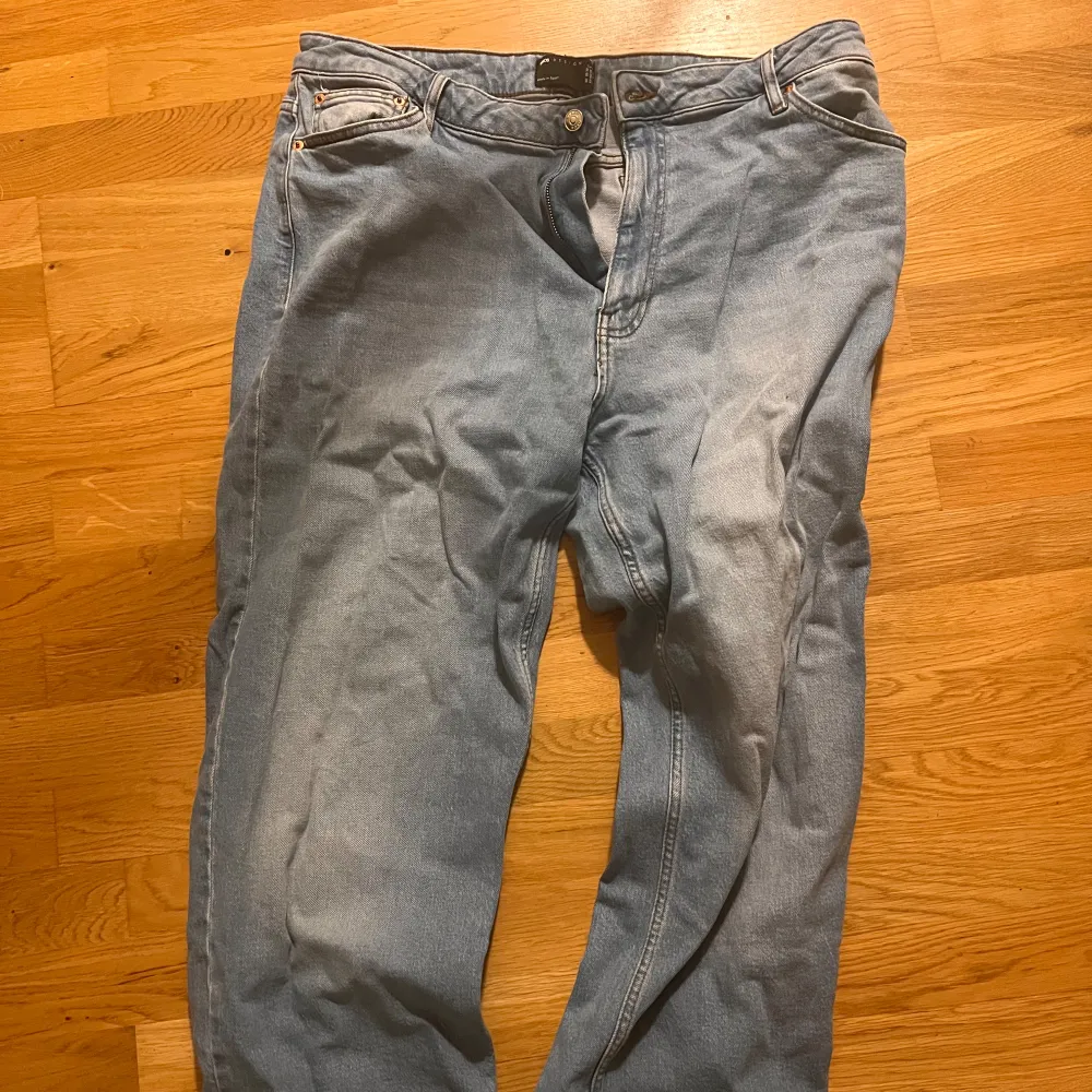 Säljer ett par ljusblå jeans i bra skick. De har en klassisk femficksdesign med knapp och dragkedja fram. Perfekta för vardagsbruk och kan matchas med det mesta i garderoben. Passformen är normal och de är tillverkade i ett slitstarkt jeanstyg.. Jeans & Byxor.