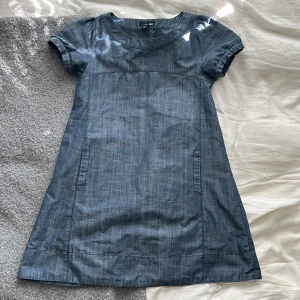 Söt jeansklänning - En jättefin jeansklänning som är köpt vintage men är ursprungligen från h&m. Två fickor på framsidan. 