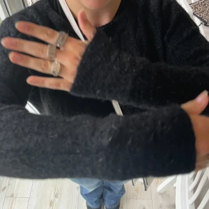 Svart stickad tröja från Guitare - Säljer en mysig svart stickad tröja från Guitare. Den har långa ärmar och en normal passform, perfekt för kyliga dagar. Tröjan är i bra skick och passar både till vardags och lite finare tillfällen. Perfekt att matcha med jeans eller kjol!