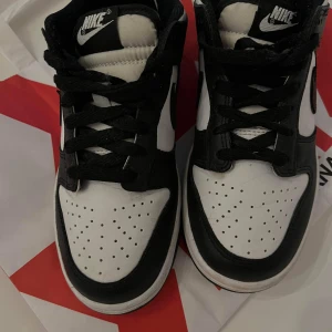 Svartvita Nike sneakers - Säljer ett par snygga svartvita Nike sneakers. De har en klassisk design med svart och vit färgkombination och är perfekta för både vardag och fest. Skorna har snörning och är i bra skick. Perfekta för dig som vill ha en stilren look!