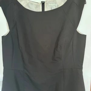 Svart fodralklänning  - Knälång med sprund baktill  Sparsamt använd 