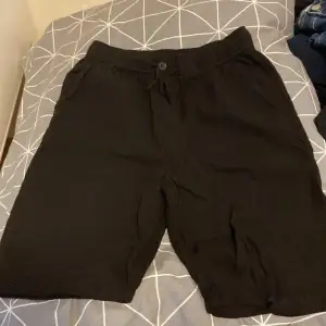 Säljer ett par svarta shorts från H&M. De har en bekväm passform med resår i midjan och en knapp framtill. Perfekta för en avslappnad stil! Och är linne shorts 