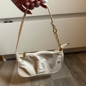 Ny liten handväska  - En kräm/beigefärgad lite handväska. Helt ny