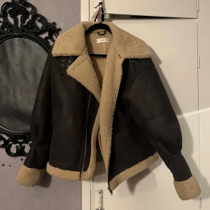 brun vinterjacka/höstjacka - materialet på utsidan ska se ut som läder men det är mjukt och lent. det står storlek S men den är stor så jag skulle säga M elelr L.(förmodligen räknar de med att man har en tjocktröja under). topp skick, använd ca 3 ggr. använd köp nu!
