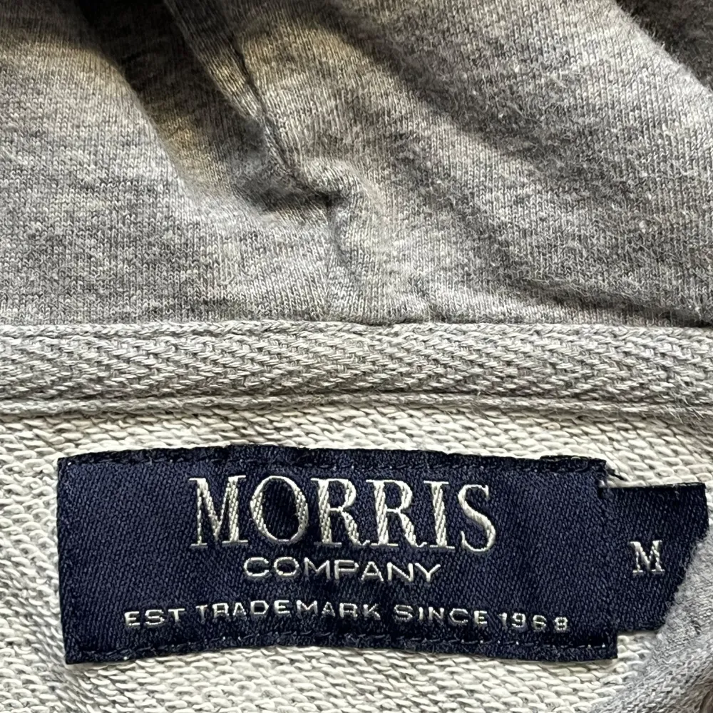 Säljer en stilren grå hoodie från Morris i storlek M. Den har en dragkedja framtill och en broderad detalj på bröstet. Perfekt för höst och vår🤙. Passar både till vardags och chill. Pris kan diskuteras vid snabb affär 💯🤙🤩. Tröjor & Koftor.