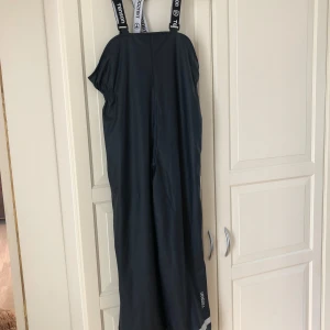 Regnbyxa från Tenson stl 146/152 - Säljer helt nya regnbyxor/skallbyxor(aldrig använda, endast provade) grå Tenson i stl 146/152. Passar perfekt till en tjej eller kille. Byxor är fodrade med värmande fleece.