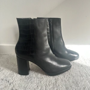 Svarta stövletter med klack - Säljer mammas nyköpta och oanvändbara svarta PACE stövletter/ankelboots som är i äkta läder. Klacken är 8,5 cm hög. Perfekta för höst och vinter! Nypris: 1200kr