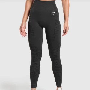 Svarta leggings från Gymshark - Snygga svarta leggings från Gymshark med hög midja och tight passform. Perfekta för träning med sitt stretchiga och bekväma material. Diskret logga på låret och vid vristen.