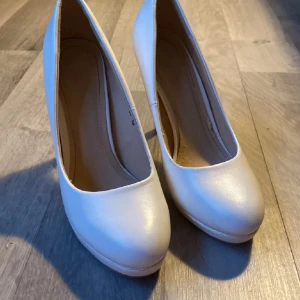 Vita pumps - Eleganta vita pumps med rundad tå och hög klack. Strl 37, ganska använda lite slitna men inget man märker av från utsidan 