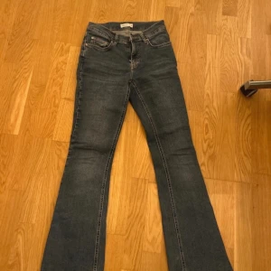 Blå bootcut jeans Gina tricot - Snygga blå bootcut jeans med klassisk femficksdesign. Perfekta för en avslappnad stil med en touch av retro. Lite slitna längst ned men annars väldigt fina, om du undrar något är det bara att skriva!