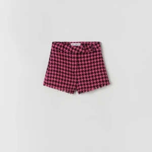 Rosa och svarta rutiga shorts - Snygga rosa och svarta shorts med ett klassiskt rutigt mönster. De har en hög midja och en fransig kant nedtill som ger en trendig look. Perfekta för att sticka ut i mängden! Skulle säga att de passar bra på en strl 34