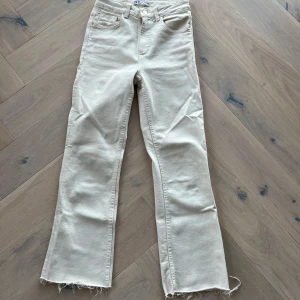 Beige jeans från Zara - Snygga beige jeans från Zara med fransiga kanter. Flare modell och mid waist. Normal i storlek.
