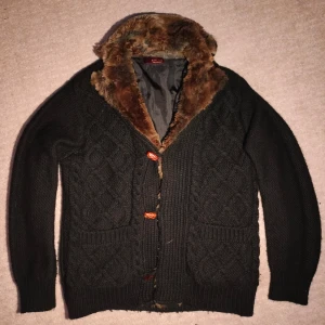 Päls fodrad stickad cardigan  - Säljer en varm pälsfodrad stickad cardigan. Stilren design med trä knappar och brun tjock päls, perfekt till lite kallare väder. Skriv vid minsta fundering!