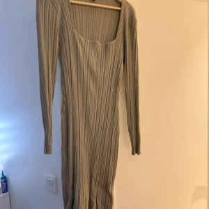Ribbad klänning från H&M - Säljer en stilren ribbad från H&M i en neutral färgton. Klänningen har en åtsittande passform med långa ärmar och en rundad halsringning. Perfekt för en chic och avslappnad look. Ganska stretchig och använd en gång under ett tillfälle❤️