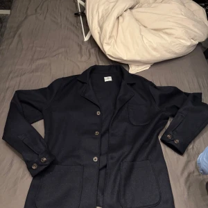 Overshirt John Henric  - Snygg mörkblå Overshirt från John Henric med klassisk design. overshirten har knappar framtill och två fickor. Perfekt för en stilren look. Använd Max 3 gånger 