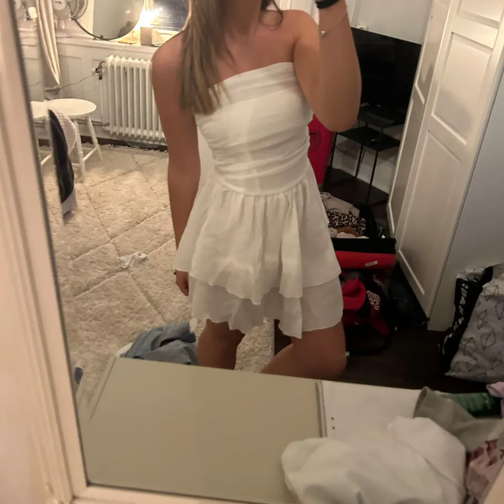 Säljer en söt vit axelbandslös klänning💕 helt oanvänd, stretchig i storleken, pris kan diskuteras . Mekot.