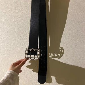 Svart bälte med silverdetaljer - Snyggt svart bälte med ett silverfärgad spänne. 