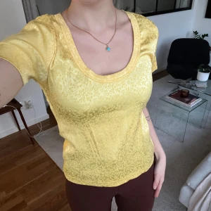 Gul t-shirt - En t-shirt i fint material och blommigt mönster