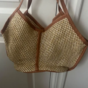Strandväska - Jättefin strandväska liknande, köpt ifrån sellpy så vet inte märket. Mycket bra skick, jag själv har aldrig använt den. Så fina bruna detaljer