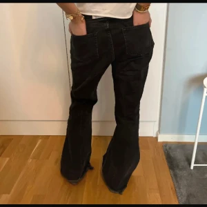 Svarta bootcut jeans - Snygga svarta bootcut jeans med hög midja. Perfekta för en trendig look. De har en klassisk femficksdesign och en bekväm passform.