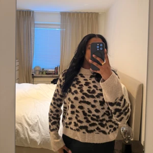 Beige leopardmönstrad tröja - Säljer en snygg beige tröja med leopardmönster. Tröjan har långa ärmar och en rund halsringning. Perfekt för att ge din outfit en trendig touch 🐆