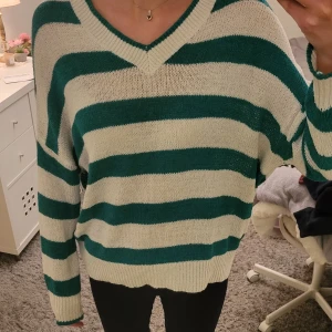 Vit och grön randig stickad tröja - En jättefin stickad tröja som jag använt några gånger, superfin att ha över ett linne eller en bikini på sommaren! Den är tunn och lite genomskinlig men är i perfekt skick🩷 Lite lång i armarna men inte något som är störigt!🩷