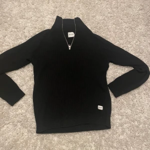 Jack o Jones halfzip  - Säljer en svart halfzip från Jack o Jones med dragkedja vid halsen. Endast använd en gång. Nypris 599kr