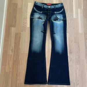 Seyoo bootcut jeans - Ett par jättefina jeans från märket Seyoo som har en cool mörkblå och ljusblå wash med fina detaljer. Skicket är 10/10 och har inga defekter. Coola fickor både på baksidan och framsidan samt en bootcut modell. Skriv gärna om ni har några frågor!!