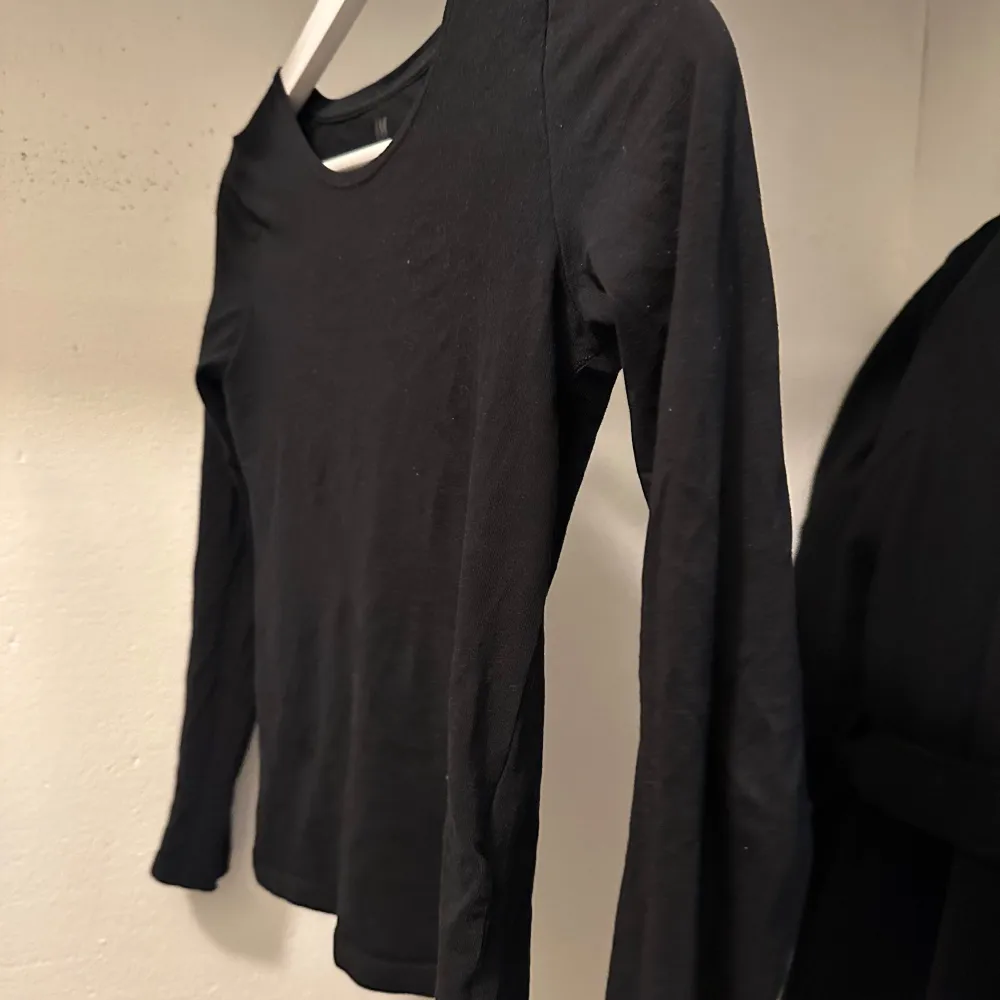 Säljer en stilren svart långärmad topp. Perfekt för lager-på-lager eller som den är. Enkel design med rund halsringning.. Neuletakit & Villapaidat.