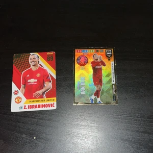 Fotbollskort med Zlatan Ibrahimović och Virgil van Dijk - Två fotbollskort, ett med Zlatan Ibrahimović i Manchester United-tröja och ett med Virgil van Dijk. Zlatans kort har detaljer om hans födelsedatum, längd och vikt, samt hans landslag. Van Dijks kort har en glittrande design och är märkt med FIFA 365.