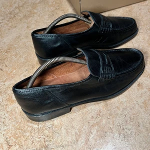 Svarta loafers från Tonio Del Prete storlek 44 - Snygga och välhållna Tomino del Prete loafers i svart läder. Skorna är i gott skick och redo att användas. De har en klassisk design som passar till många olika tillfällen. Italiensk tillverkade loafers med äkta bekväm läder i helt svart färg. Skorna har skydd på yttersulan och är nypolerade. De är true to size och är endast använda 1 gång mest inomhus.