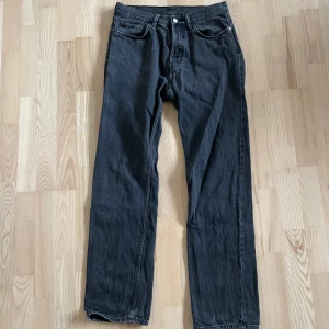 Svarta jeansbyxor - Säljer ett par svarta jeansbyxor. Perfekta för både vardag och fest. Midjan är normalhög och byxorna har en knapp och dragkedja framtill. Modellen heter space från weekday och är straight fit. Storleken är w30 L34