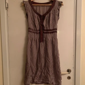 Klänning - Säljer en jättefin klänning som tyvärr inte kommer till användning. Knytband framtill och volangdetaljer vid axlarna. Säljs pga kommer inte till användning🍁skriv för fler bilder eller vid frågor! Öppen för prutning 