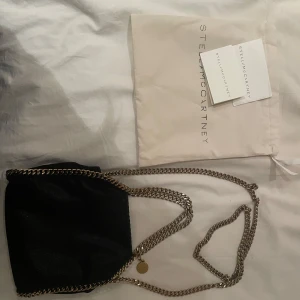 Stella McCartney väska - Super fin Stella McCartney väska i modellen falabella - svart med guld detaljer, jätte fint skick och äkthetsbevis finns!