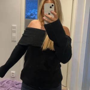 Svart offshoulder tröja från H&M - Säljer en superfin svart offshoulder tröja från H&M. Den är perfekt för både höst och vinter med sin mysiga och stilrena design. Tröjan har långa ärmar och en lös passform som gör den bekväm att bära. Perfekt för en chill dag eller en kväll ute! 🖤